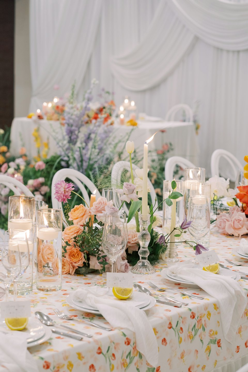 Elegant event table set with floral patterns and candles.