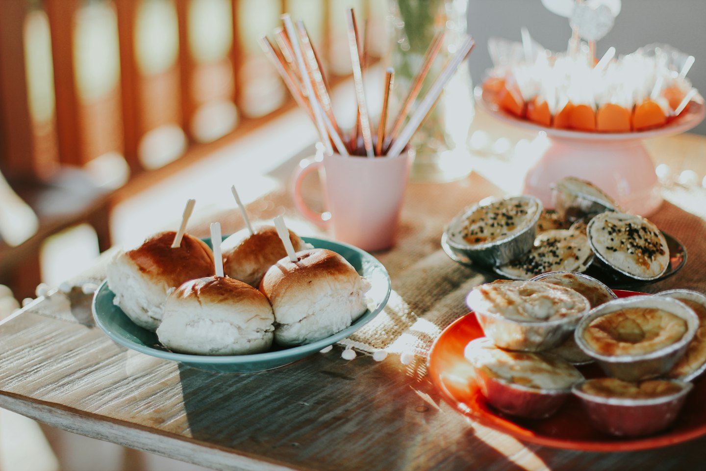 Mini sliders and savory pies arranged on a wooden table.