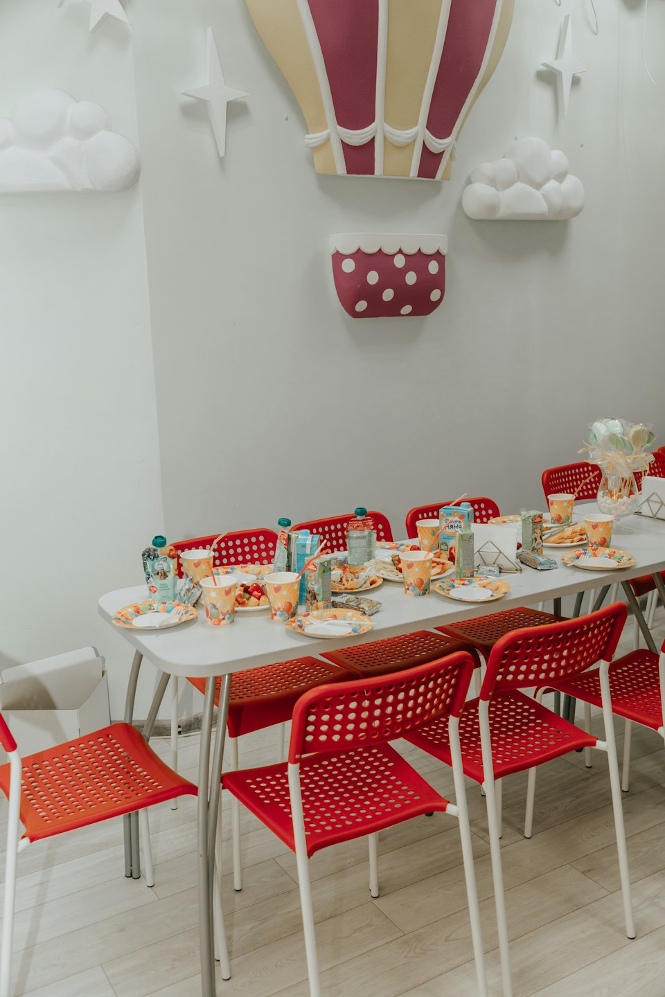 Table set for a party with colorful plates and decorations.