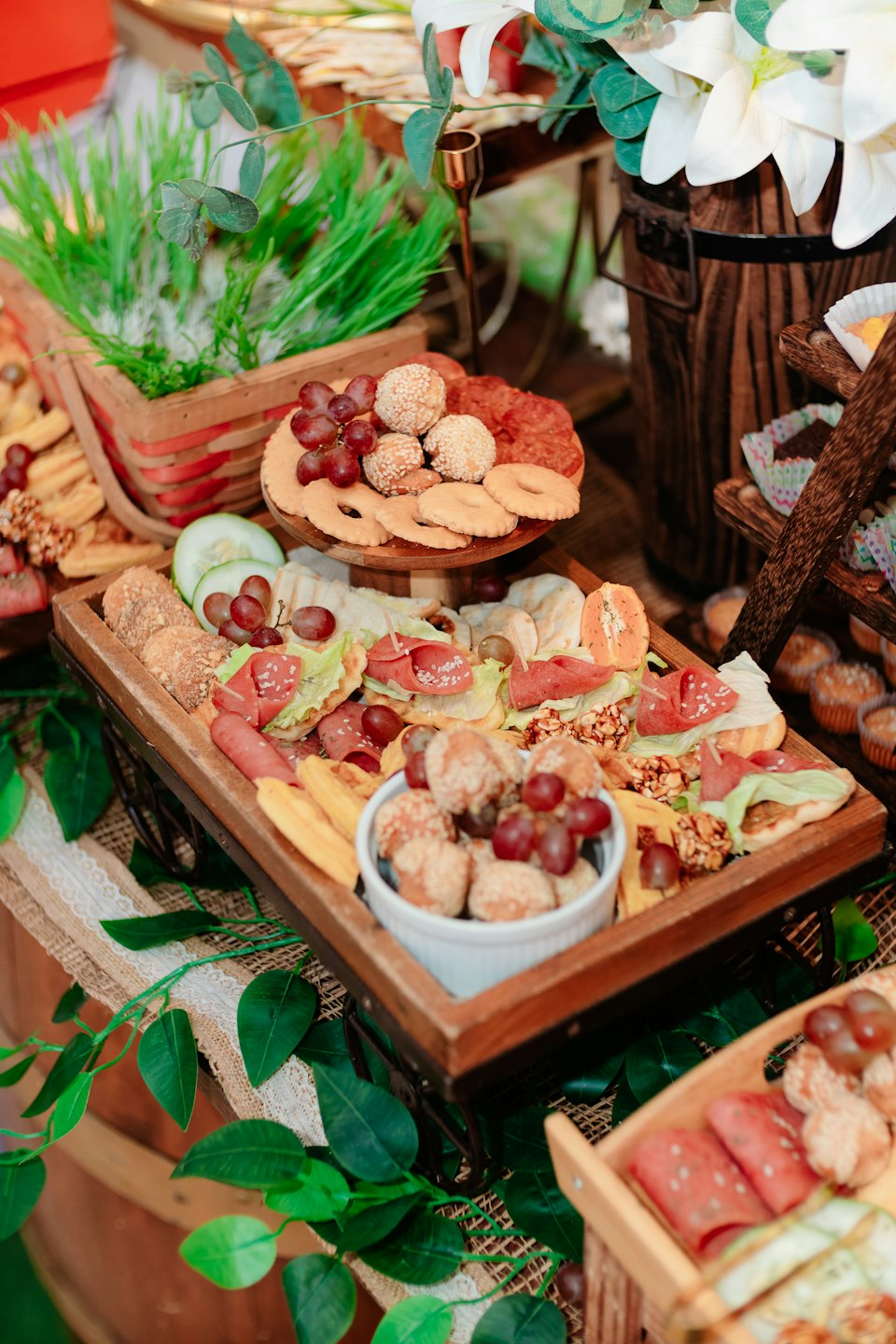 Assortment of mini sandwiches and snacks on wooden platters.
