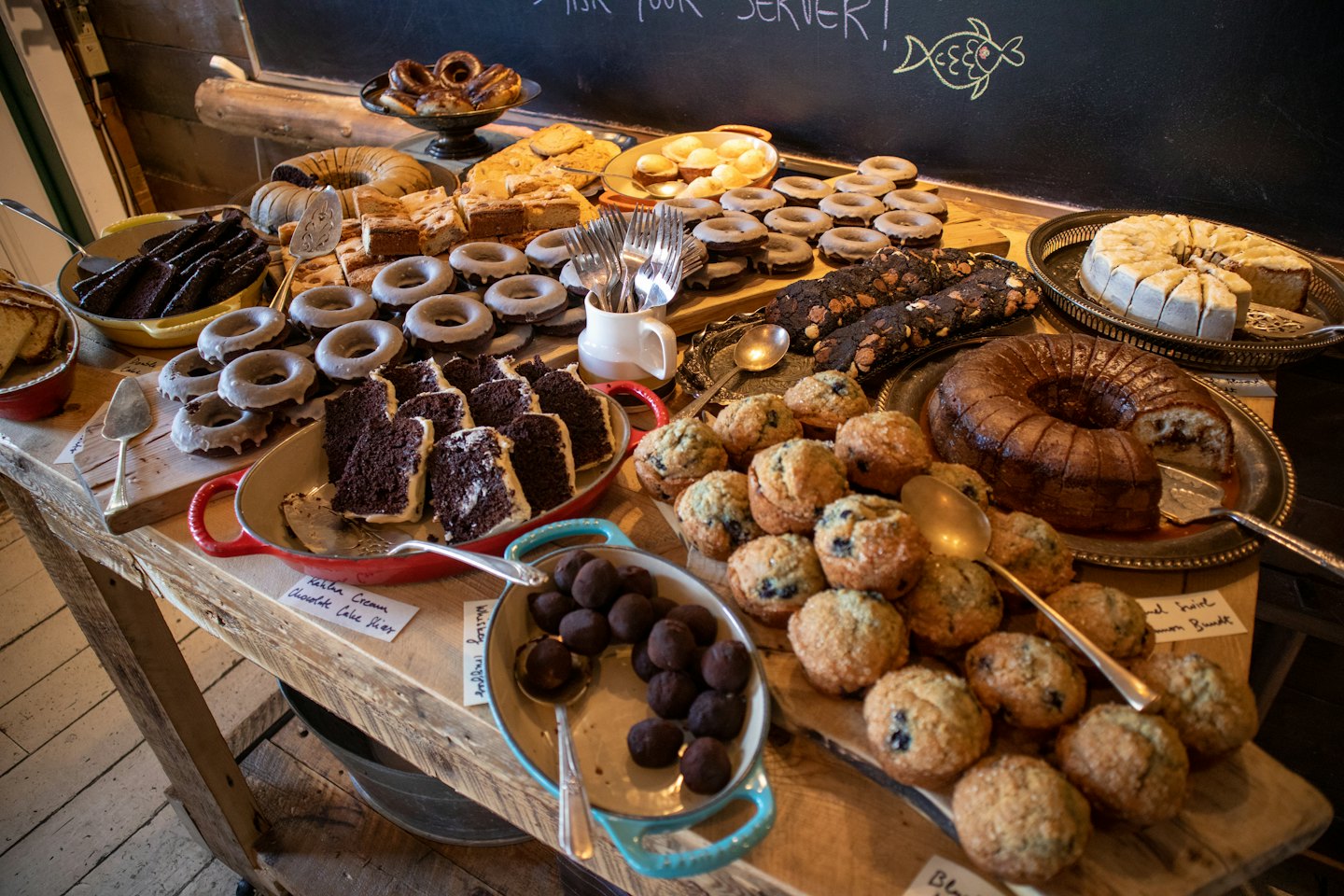 Assorted pastries and cakes displayed on a rustic wooden table.