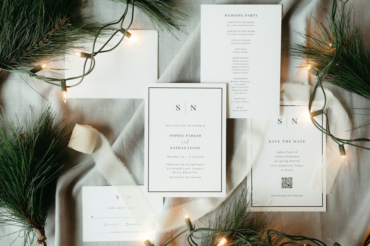 Wedding stationery and pine branches on grey linen.