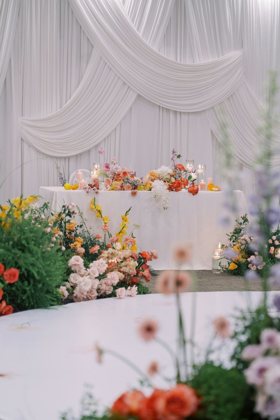 An event table features floral arrangements, candles, and citrus fruits.